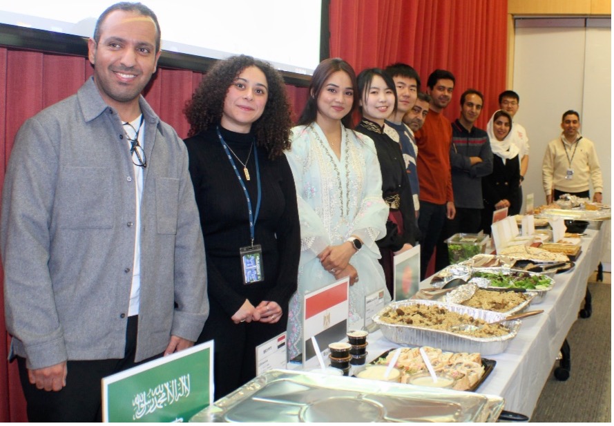 Students standing in front of their country's food dish