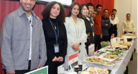 Students standing in front of their country's food dish